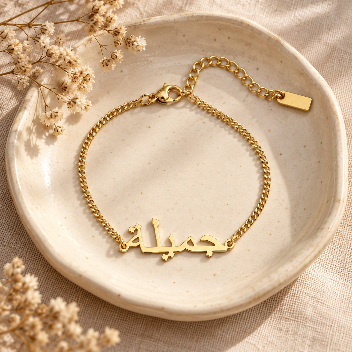 The Custom Name Bracelet in a ceramic trinket dish