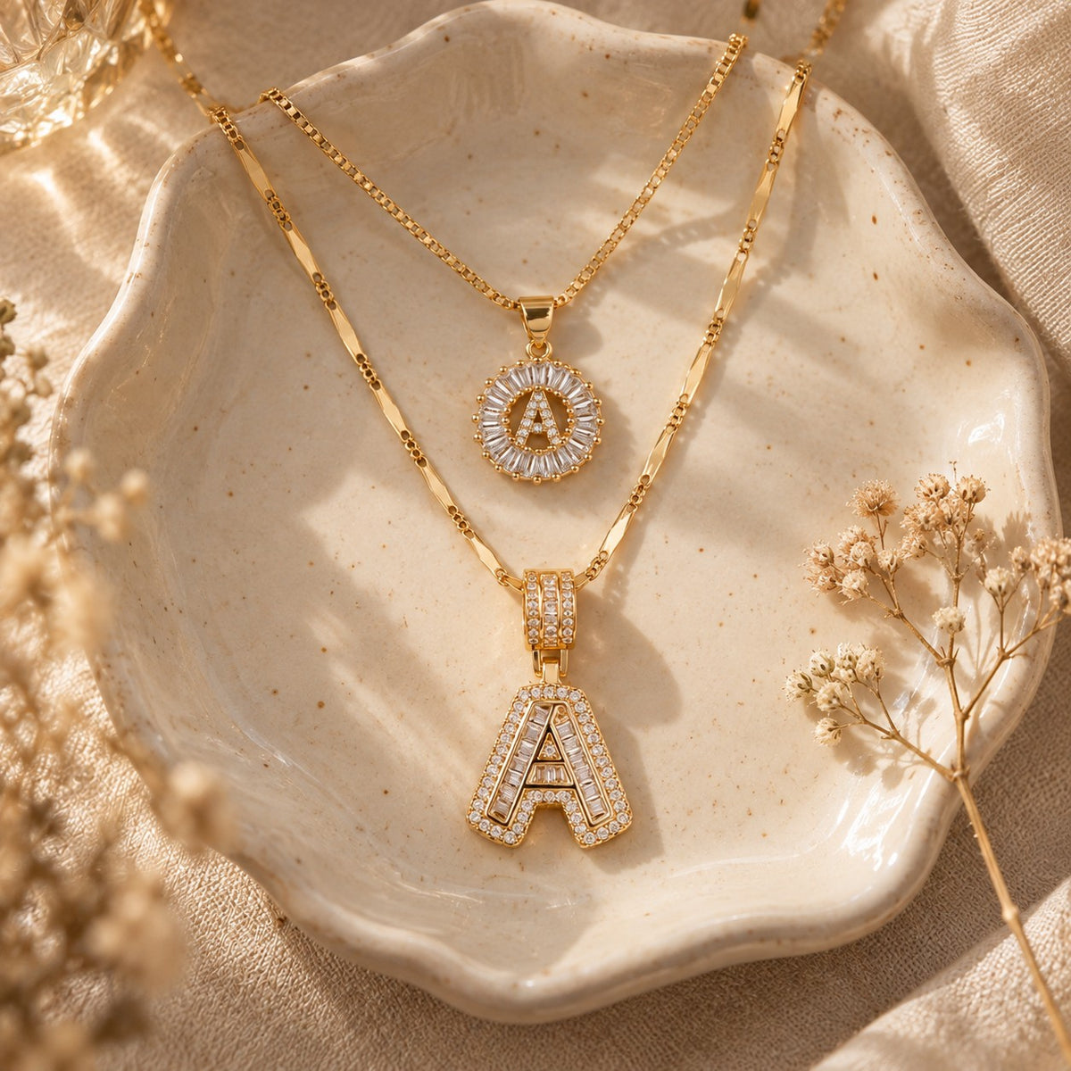The 2pc 14k Diamond Letter Initial Necklaces in a ceramic trinket dish