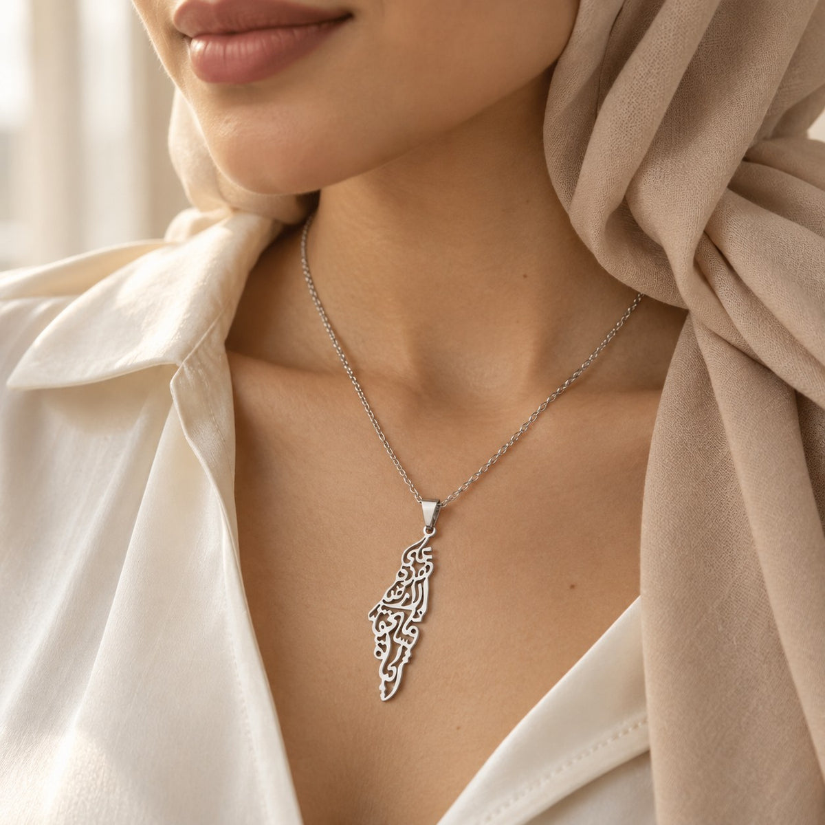 Woman wearing the Palestine Calligraphy Map Necklace in silver