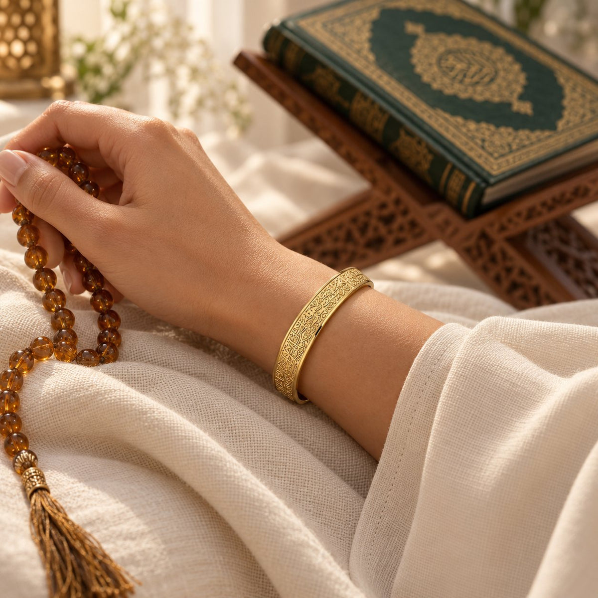 A woman wearing the engraved Ayatul Kursi cuff while holding amber prayer beads