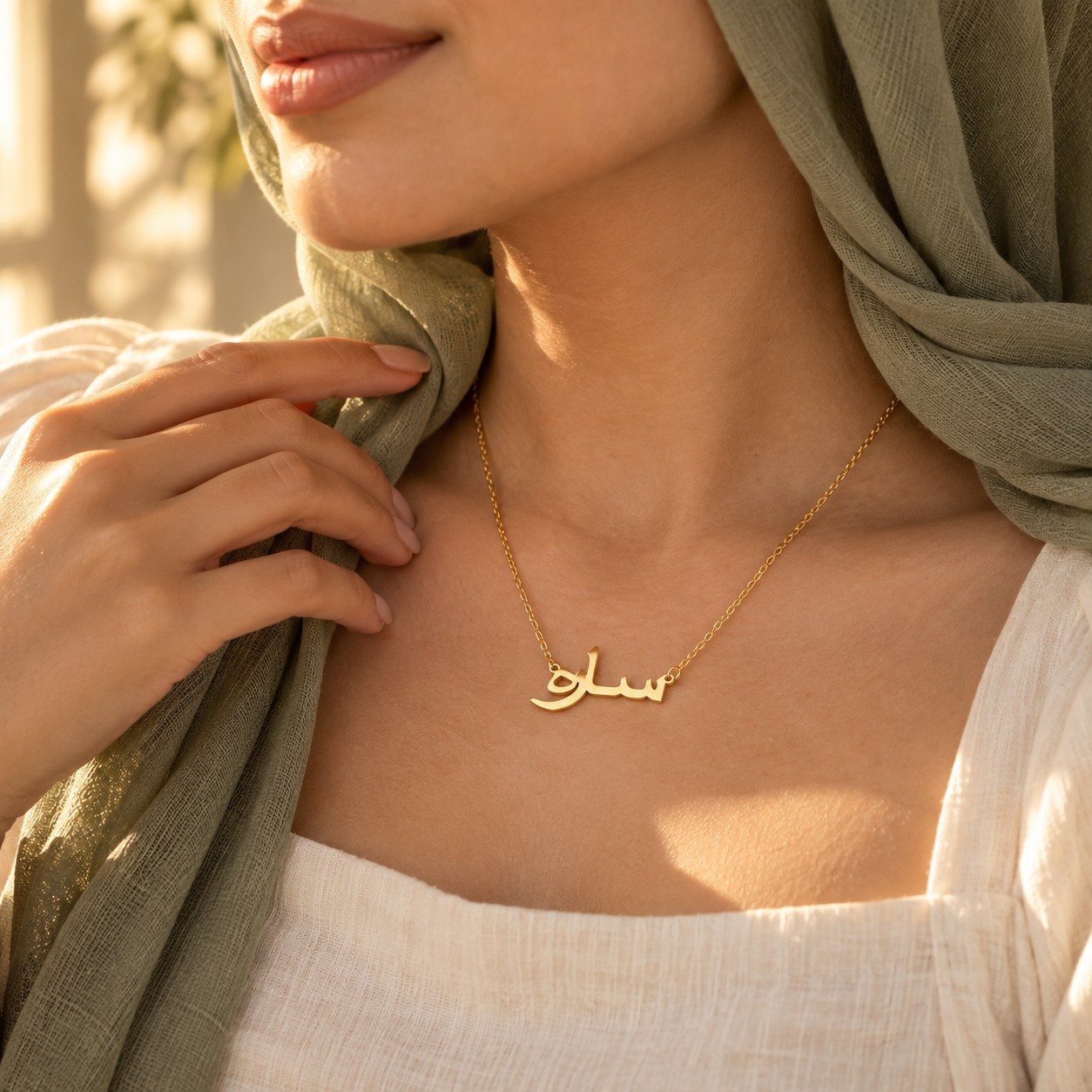 A woman wearing a gold Arabic name necklace
